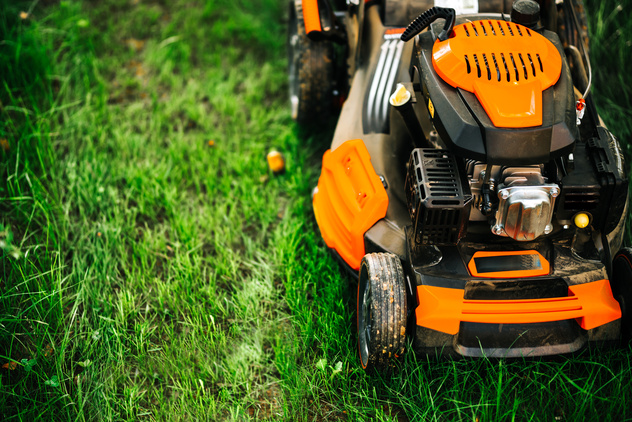 A stock image of a lawnmower mowing grass.